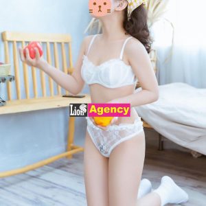 A 707 escort girl in white lingerie seductively holding an apple.